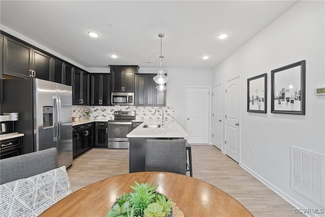 8034 Wistar Glen Dr Unit A, Henrico, VA 23228 - kitchen featuring appliances with stainless steel finishes, light wood-type flooring, light countertops, decorative backsplash, and dark cabinets