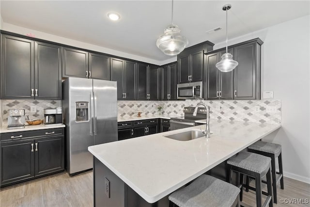 8034 Wistar Glen Dr Unit A, Henrico, VA 23228 - kitchen with stainless steel appliances, light wood-style floors, a kitchen bar, and dark cabinetry