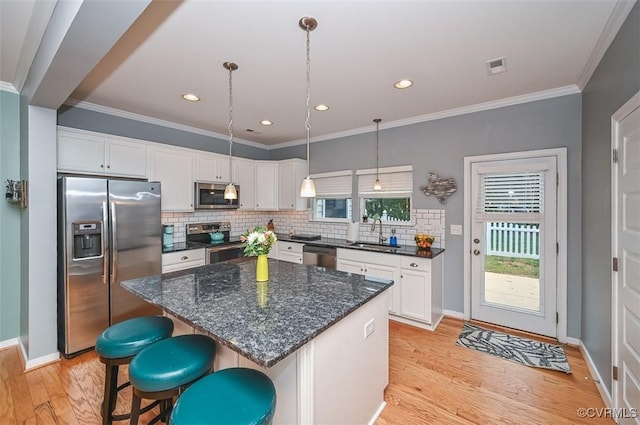 8013 Rutland Village Dr, Mechanicsville, VA 23116 - kitchen featuring stainless steel appliances, white cabinets, light wood-type flooring, a kitchen island, and tasteful backsplash