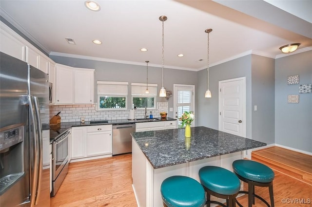 8013 Rutland Village Dr, Mechanicsville, VA 23116 - kitchen featuring stainless steel appliances, white cabinets, light wood-type flooring, tasteful backsplash, and crown molding