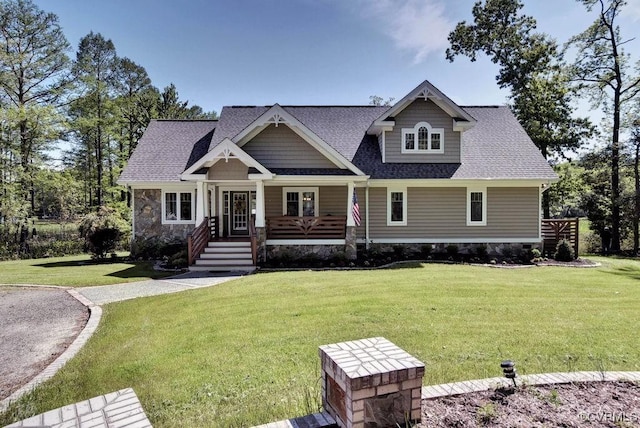 258 Sandy Bay Rd, Williamsburg, VA 23185 - view of front of house with a front yard, covered porch, a shingled roof, and stone siding