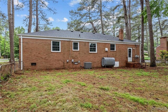 6808 Montauk Dr, Richmond, VA 23225 - back of house with oil tank, a chimney, brick siding, and crawl space