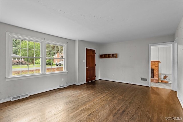 6808 Montauk Dr, Richmond, VA 23225 - unfurnished living room with wood finished floors and a brick fireplace