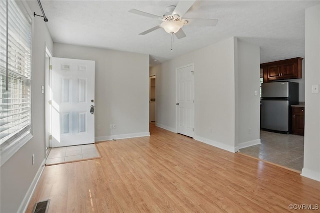 108 N Cedar Ave, Highland Springs, VA 23075 - unfurnished living room featuring healthy amount of natural light, light wood-type flooring, and a ceiling fan