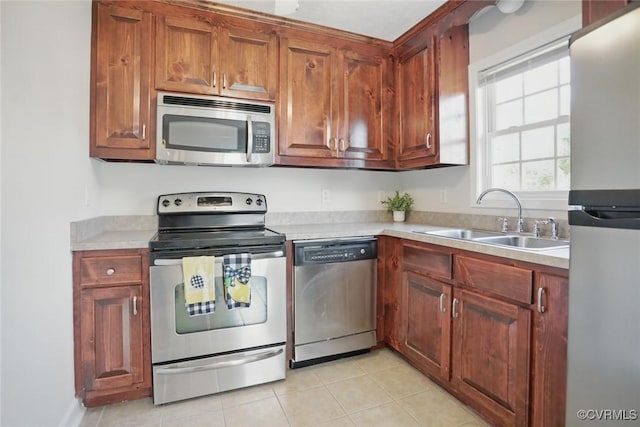 108 N Cedar Ave, Highland Springs, VA 23075 - kitchen with stainless steel appliances, light countertops, light tile patterned floors, and brown cabinets