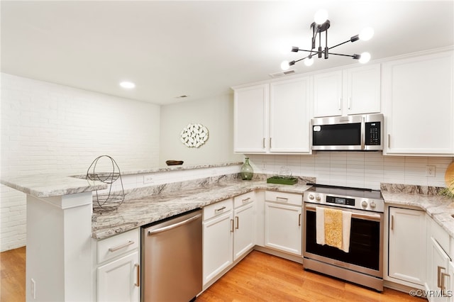 1716 Summit Ave Unit 18, Richmond, VA 23230 - kitchen featuring stainless steel appliances, a peninsula, light wood-style floors, decorative backsplash, and white cabinets
