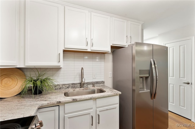 1716 Summit Ave Unit 18, Richmond, VA 23230 - kitchen featuring appliances with stainless steel finishes, white cabinetry, backsplash, light stone countertops, and light wood-type flooring