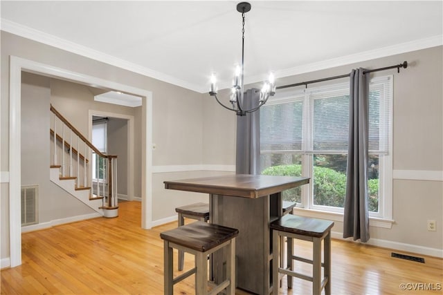107 Oak Ridge Ct, Williamsburg, VA 23188 - dining area featuring light wood finished floors, a chandelier, healthy amount of natural light, crown molding, and stairway