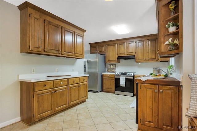 107 Oak Ridge Ct, Williamsburg, VA 23188 - kitchen with appliances with stainless steel finishes, under cabinet range hood, brown cabinets, light countertops, and light tile patterned flooring