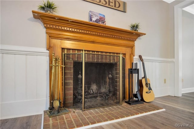 107 Oak Ridge Ct, Williamsburg, VA 23188 - detailed view of a brick fireplace, wood finished floors, and a wainscoted wall