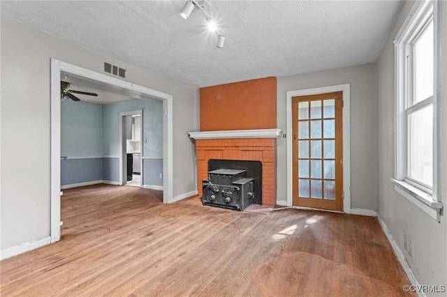 4123 Bremner Blvd, Henrico, VA 23228 - unfurnished living room featuring light wood finished floors, plenty of natural light, ceiling fan, a textured ceiling, and rail lighting