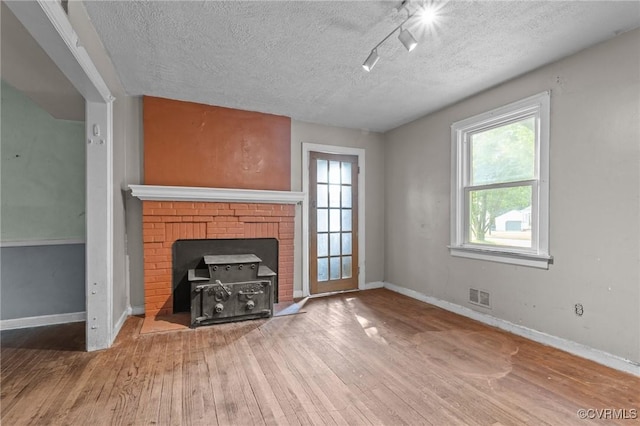 4123 Bremner Blvd, Henrico, VA 23228 - unfurnished living room featuring a textured ceiling, wood finished floors, healthy amount of natural light, and a fireplace