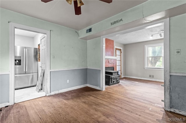4123 Bremner Blvd, Henrico, VA 23228 - unfurnished living room featuring a ceiling fan, a wood stove, and hardwood / wood-style flooring