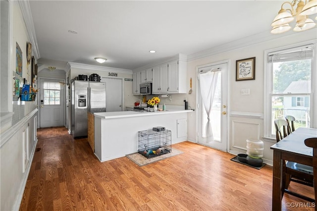 9220 Brocket Dr, Midlothian, VA 23112 - kitchen featuring stainless steel appliances, crown molding, light countertops, a peninsula, and dark wood-type flooring