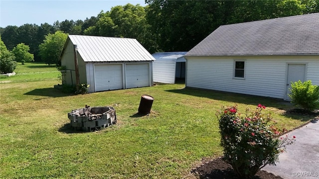 6010 Courthouse Rd, Prince George, VA 23875 - view of grassy yard featuring a detached garage, an outbuilding, and a fire pit