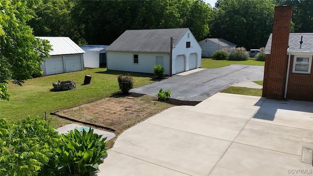 6010 Courthouse Rd, Prince George, VA 23875 - view of green lawn featuring an outdoor fire pit, an outbuilding, and a garage