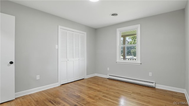 6010 Courthouse Rd, Prince George, VA 23875 - unfurnished bedroom featuring a baseboard radiator, light wood-style flooring, and a closet