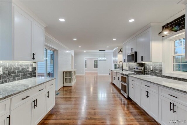 12309 Main St, Stony Creek, VA 23882 - kitchen featuring stainless steel appliances, backsplash, white cabinets, crown molding, and wood finished floors