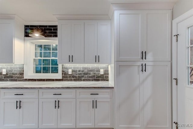 12309 Main St, Stony Creek, VA 23882 - kitchen with white cabinets, decorative backsplash, and light stone countertops