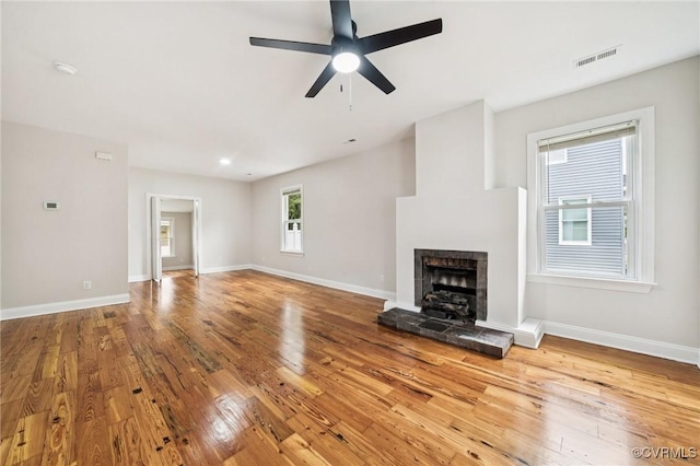 627 Colonial Ave, Colonial Heights, VA 23834 - unfurnished living room with hardwood / wood-style flooring, a fireplace with raised hearth, and a ceiling fan