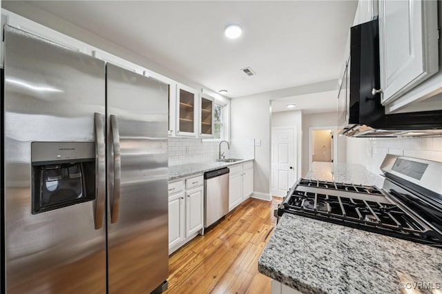 627 Colonial Ave, Colonial Heights, VA 23834 - kitchen featuring stainless steel appliances, light wood-style flooring, white cabinets, decorative backsplash, and light stone countertops