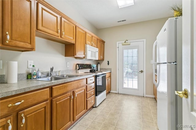 262 Claiborne Dr, Williamsburg, VA 23185 - kitchen with white appliances, brown cabinetry, light countertops, and light flooring