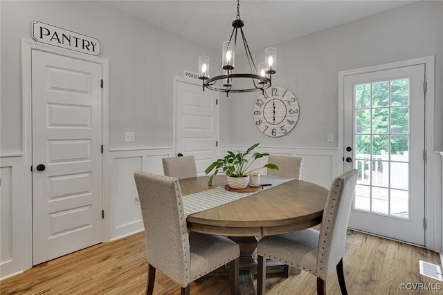 6504 Sanford Springs Cv, Midlothian, VA 23112 - dining area with a chandelier, a wainscoted wall, light wood-type flooring, and a decorative wall