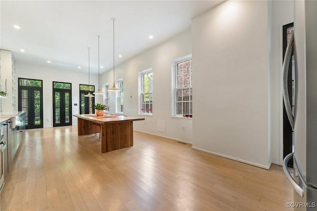 2417 E Grace St, Richmond, VA 23223 - kitchen featuring freestanding refrigerator, a center island, light wood-type flooring, recessed lighting, and hanging light fixtures