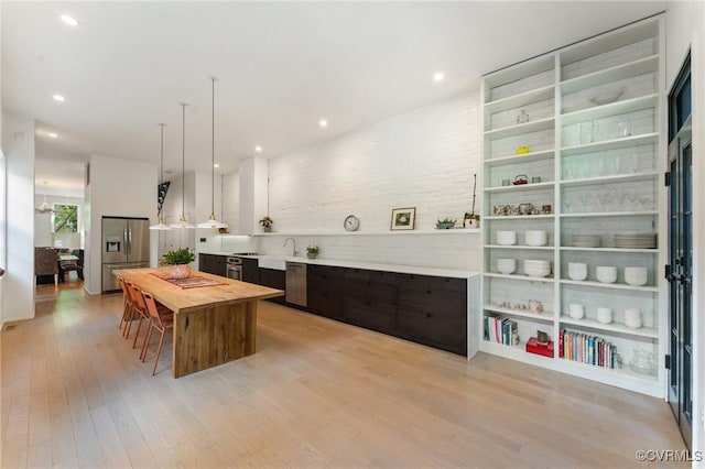 2417 E Grace St, Richmond, VA 23223 - kitchen featuring appliances with stainless steel finishes, wooden counters, light wood-type flooring, a kitchen island, and hanging light fixtures