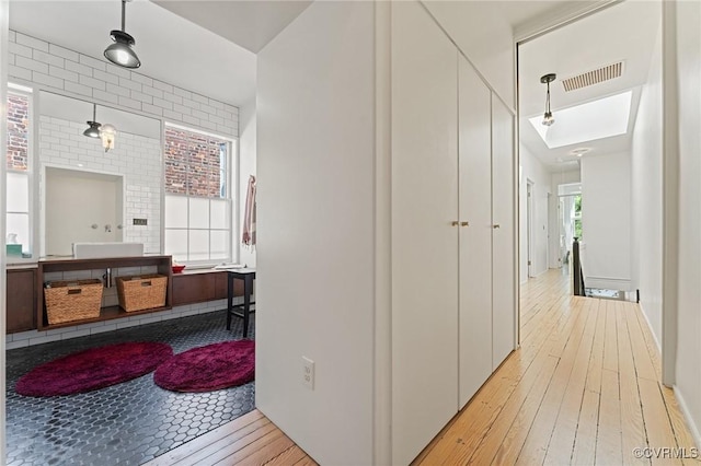 2417 E Grace St, Richmond, VA 23223 - hallway with light wood-style flooring and a skylight