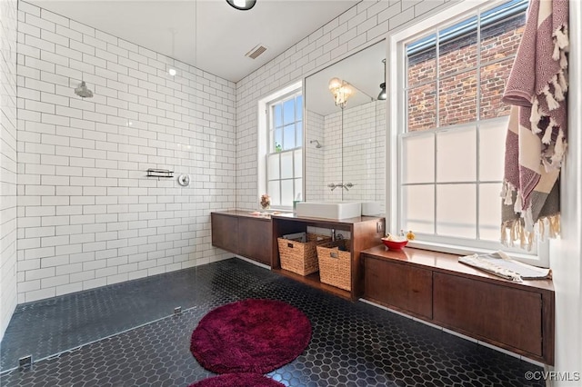 2417 E Grace St, Richmond, VA 23223 - bathroom with tile walls, tile patterned flooring, tiled shower, and vanity