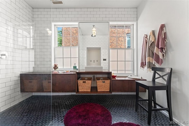 2417 E Grace St, Richmond, VA 23223 - full bathroom with vanity, tile patterned flooring, tiled shower, and tile walls