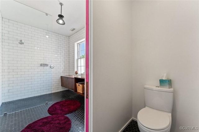 2417 E Grace St, Richmond, VA 23223 - bathroom featuring a tile shower, vanity, tile patterned flooring, and tile walls