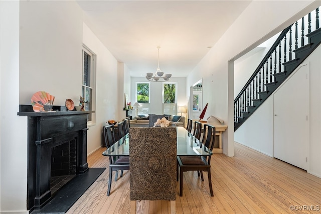 2417 E Grace St, Richmond, VA 23223 - dining space featuring stairs, a fireplace, and light wood-style flooring