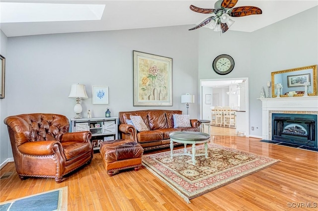 10151 W Providence Rd, North Chesterfield, VA 23236 - living room featuring wood finished floors, ceiling fan, high vaulted ceiling, a skylight, and a tiled fireplace