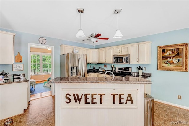 10151 W Providence Rd, North Chesterfield, VA 23236 - kitchen featuring appliances with stainless steel finishes, cream cabinets, a ceiling fan, dark stone countertops, and a center island with sink