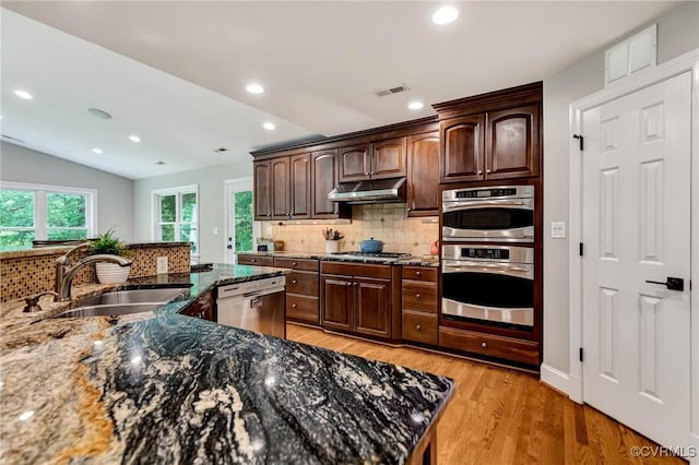 9065 Greenlake Cir, Mechanicsville, VA 23116 - kitchen with appliances with stainless steel finishes, tasteful backsplash, under cabinet range hood, dark stone counters, and recessed lighting
