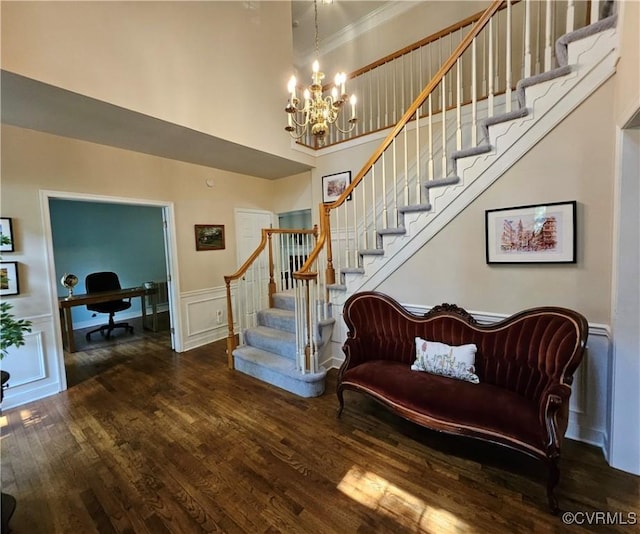 10278 Henderson Hall Rd, Mechanicsville, VA 20116 - stairway featuring a towering ceiling, wood finished floors, a chandelier, wainscoting, and a decorative wall