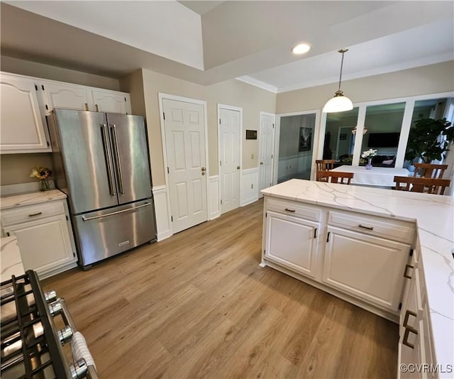 10278 Henderson Hall Rd, Mechanicsville, VA 20116 - kitchen with freestanding refrigerator, white cabinets, light wood-style flooring, a wainscoted wall, and hanging light fixtures