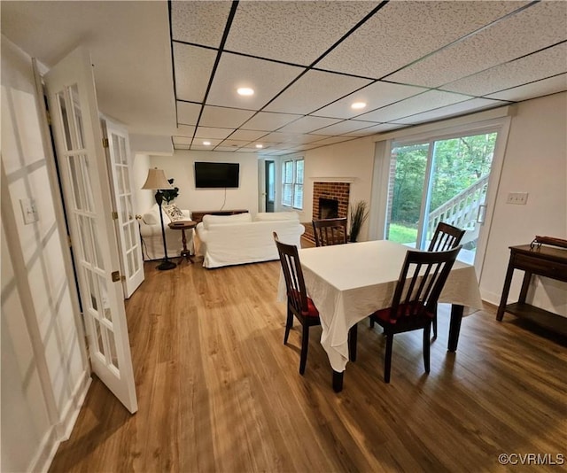 10278 Henderson Hall Rd, Mechanicsville, VA 20116 - dining room featuring wood finished floors, a brick fireplace, recessed lighting, and french doors