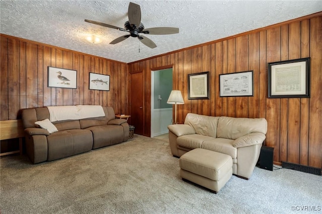 2000 Point Of Rocks Rd, Chester, VA 23836 - living room featuring a ceiling fan, carpet, a textured ceiling, wood walls, and ornamental molding