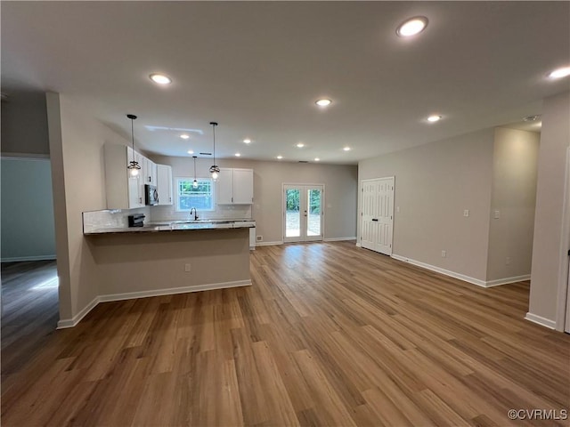 8104 Strath Rd, Henrico, VA 23231 - kitchen featuring stainless steel microwave, white cabinets, a peninsula, wood finished floors, and open floor plan