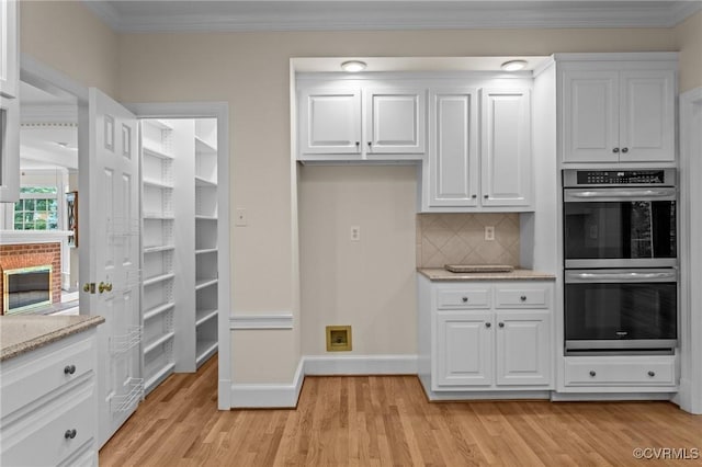 9261 Royal Grant Dr, Hanover, VA 23116 - kitchen featuring double oven, light wood-style floors, white cabinetry, and crown molding