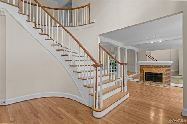 9261 Royal Grant Dr, Hanover, VA 23116 - stairway with wood finished floors, a brick fireplace, and ornamental molding