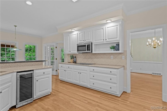 9261 Royal Grant Dr, Hanover, VA 23116 - kitchen featuring beverage cooler, stainless steel microwave, ornamental molding, black electric cooktop, and white cabinetry