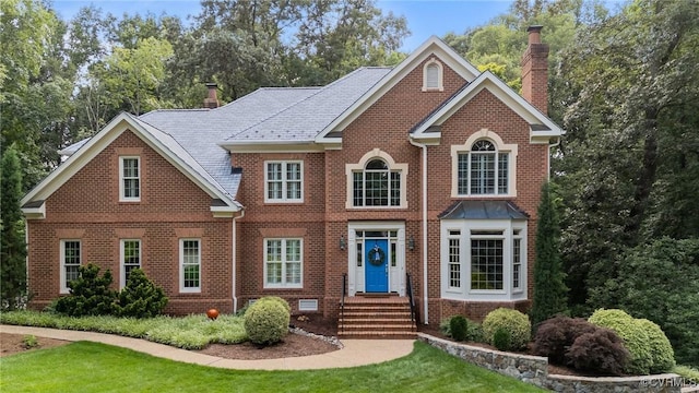 9261 Royal Grant Dr, Hanover, VA 23116 - colonial home with a chimney, brick siding, and a front yard