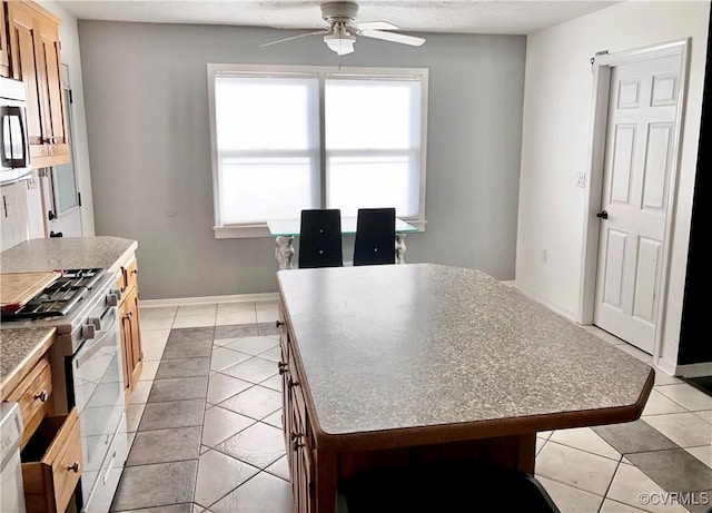 31368 Old Dawn Rd, Hanover, VA 23069 - kitchen with appliances with stainless steel finishes, ceiling fan, a kitchen island, light tile patterned floors, and plenty of natural light