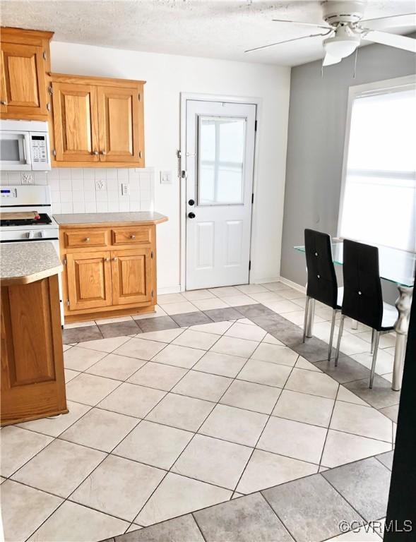 31368 Old Dawn Rd, Hanover, VA 23069 - kitchen featuring white appliances, light countertops, ceiling fan, tasteful backsplash, and light tile patterned floors