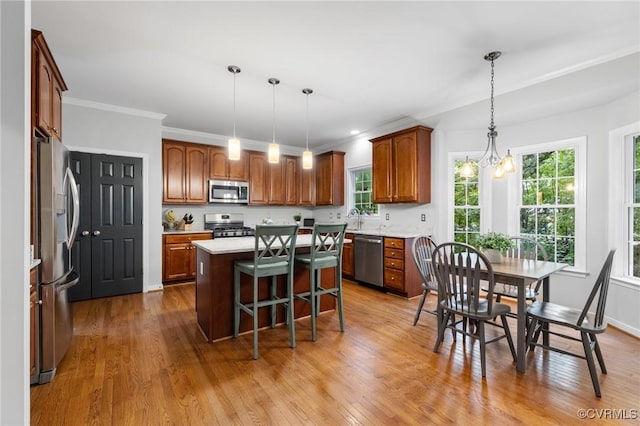 6530 Southshore Dr, Midlothian, VA 23112 - kitchen with appliances with stainless steel finishes, a kitchen island, wood finished floors, light countertops, and ornamental molding