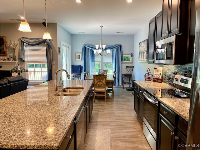 15518 Centerline Ct, Chesterfield, VA 23832 - kitchen with stainless steel appliances, light wood finished floors, a chandelier, a kitchen island with sink, and hanging light fixtures